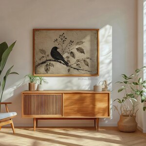 Peut inclure: Une impression d'art murale rectangulaire dans un cadre en bois clair repr&eacute;sentant un oiseau noir perch&eacute; sur une branche avec des feuilles et des baies sur un fond beige textur&eacute;. L'impression porte le texte BONA FIDES en bas &agrave; droite.