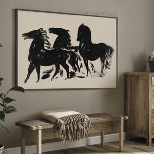 May include: Black and white abstract painting of three horses in a minimalist style. The painting is framed in a black frame and hangs on a gray wall.