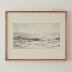 May include: A framed black and white drawing of a seascape with crashing waves. The drawing is in a light wood frame.