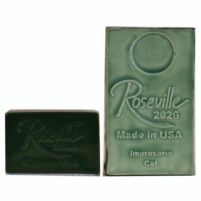 May include: Two green ceramic tiles. One is rectangular with the embossed text "Roseville 2026 Made in USA Improsario Cat". The other is a smaller, rectangular tile with the embossed text "Roseville 2026 Made in USA".