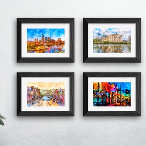 May include: Four framed watercolor paintings of cityscapes. The top left painting shows a cityscape with a river and a bridge. The top right painting shows a building with a river in front of it. The bottom left painting shows a street scene with buildings and trees. The bottom right painting shows a street scene with colorful buildings and lights.