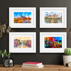 May include: Four framed watercolor paintings of cityscapes. The top left painting shows a cityscape with a river and a bridge. The top right painting shows a cityscape with a river and a building. The bottom left painting shows a cityscape with a street and buildings. The bottom right painting shows a cityscape with a street and buildings.