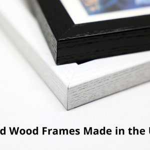 May include: Close-up of two solid wood picture frames, one black and one white. The frames are made in the USA.  Solid Wood Frames Made in the USA