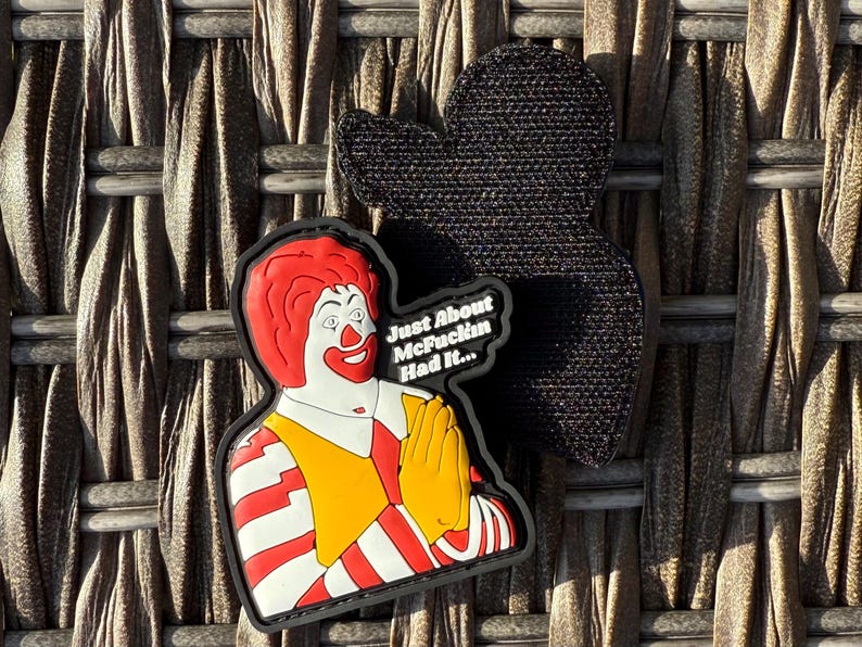 K&ouml;nnte beinhalten: Ein rot-wei&szlig; gestreiftes Patch mit einem Cartoon-Bild von Ronald McDonald mit dem Text "Just About McFuckin Had It..."