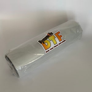May include: A gray roll of vinyl with a sticker that says "Dynamic DTF Make Your Prints Explode".