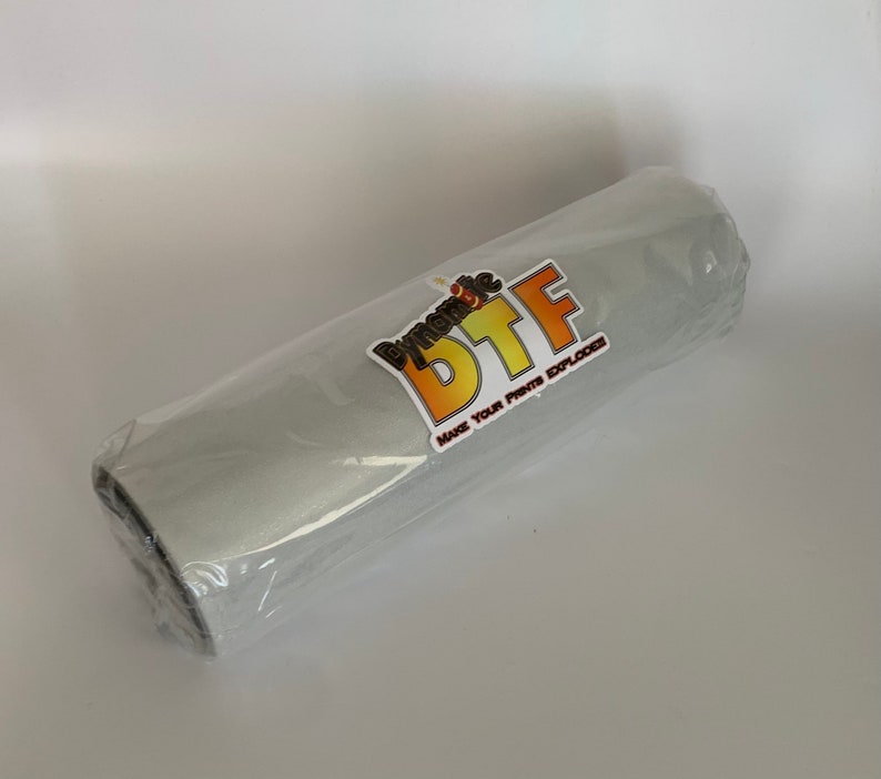 May include: A gray roll of vinyl with a sticker that says "Dynamic DTF Make Your Prints Explode".