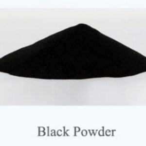 May include: A pile of black powder on a white surface. Black Powder.