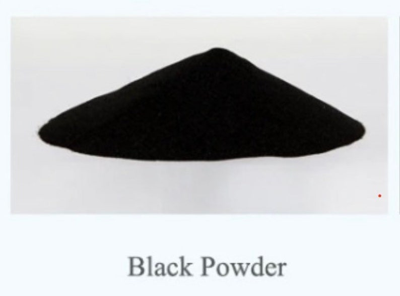May include: A pile of black powder on a white surface. Black Powder.