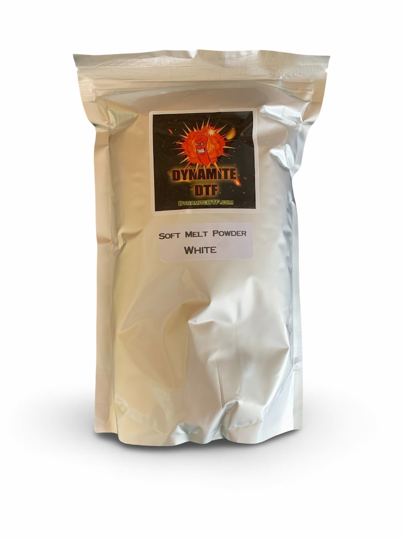 May include: A silver metallic stand-up pouch containing white soft melt powder for DTF printing. The label features a red cartoon character inside an explosion graphic with the text DYNAMITE DTF and the website DYNAMITEDTF.COM.