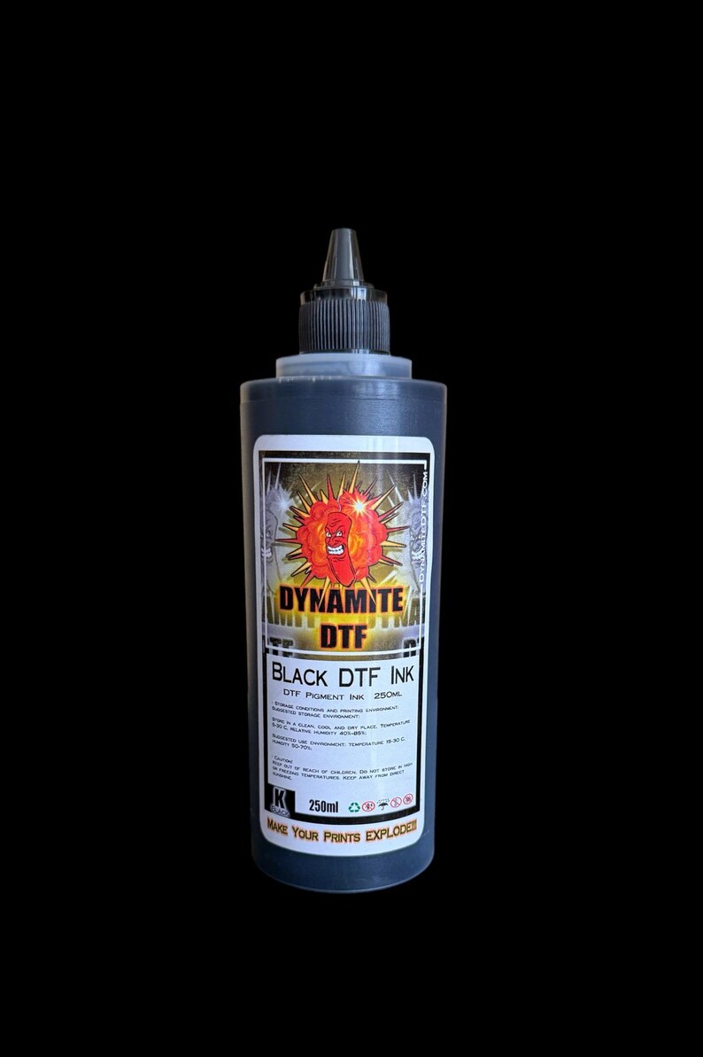 Op de afbeelding: Een zwarte plastic fles met zwarte Dynamite DTF pigmentinkt en een dop met een puntige tuit. Het etiket toont een rode cartoon-dynamietstaaf, de tekst Dynamite DTF Black DTF Ink en een inhoud van 250ml.