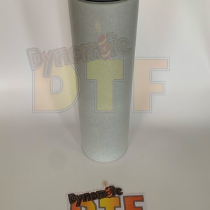 May include: A roll of silver glitter heat transfer vinyl with the text "Dynamite DTF" printed on the roll.
