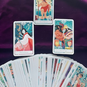 May include: A tarot deck with colorful illustrations on each card. The cards are fanned out in a semi-circle, with three cards at the top. The top cards show a man holding two staffs, a woman with three swords, and a man and woman holding two cups.