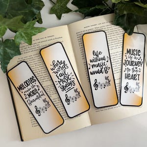 May include: Four rectangular bookmarks with black borders and inspirational quotes about music. The bookmarks have a gradient background of white and yellow. The quotes include "Melodies make life more beautiful" and "Music is a journey to the heart."