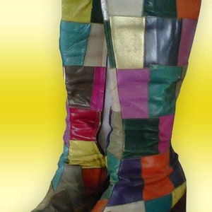 以下が含まれることがあります： カラフルなパッチワークのブーツのペアで、太いヒールが付いています。ブーツは、さまざまな色の革のピースをパッチワークのデザインで縫い合わせて作られています。ブーツは、緑、赤、紫、黄、白が混ざり合っています。