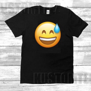 May include: Black t-shirt with a yellow smiley face emoji with a blue sweat drop on the side.