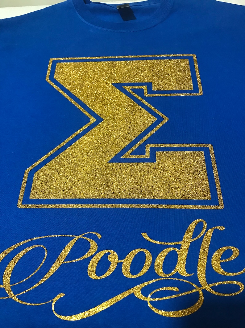 May include: A royal blue t-shirt with a gold glitter Greek letter Sigma and the word "Poodle" in gold glitter script.