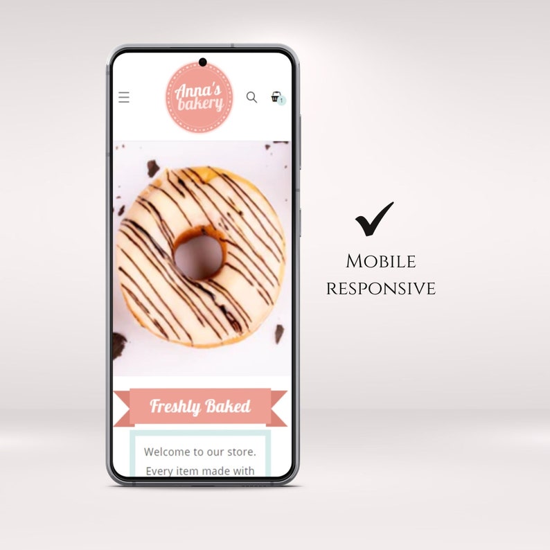 Op de afbeelding: Een mobiel telefoonscherm dat een website voor een bakkerij genaamd "Anna's Bakery" weergeeft. De website bevat een foto van een wit geglazuurde donut met chocolade-drizzle en de tekst "Freshly Baked" in een roze banner.