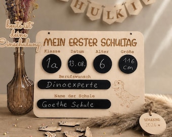 May include: A wooden sign for the first day of school with black circular and rectangular chalkboard sections for writing details like class, date, age, height, career goal, and school name, featuring a dinosaur engraving and a wooden ruler.