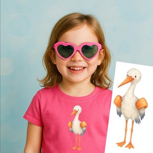 May include: A young child wearing pink heart-shaped sunglasses and a pink t-shirt featuring a watercolor illustration of a stork. The stork has orange accents and stands on thin yellow legs. The background is a light blue.
