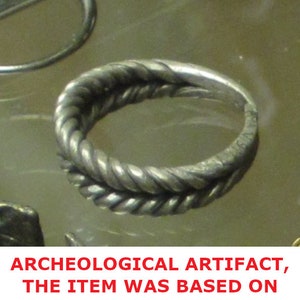 May include: A silver ring with a twisted rope design. The ring is an archeological artifact.