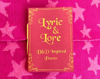 May include: A red book titled "Lyric & Lore" with gold lettering and floral corner designs. The book's subtitle reads "D&D Inspired Poems." The book is set against a pink background with white star patterns.