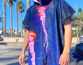 May include: A blue hooded towel with a jellyfish print. The towel has a pocket on the front and a hood with a white lining.