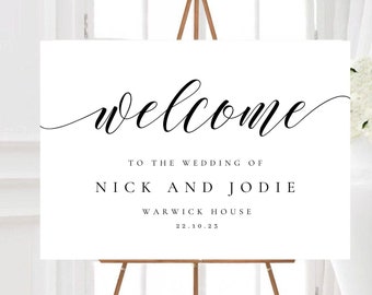 May include: White welcome sign with black calligraphy text. The text reads "Welcome to the wedding of Nick and Jodie Warwick House 22.10.23".