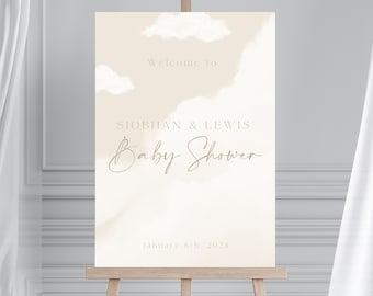 May include: A beige welcome sign with a watercolor effect featuring white clouds. The text reads "Welcome to Siobhan & Lewis' Baby Shower" and "January 6th, 2024".