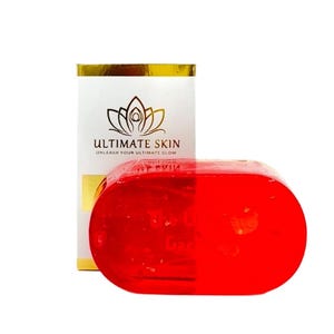May include: A red, translucent soap bar and a white box with gold detailing. The box displays the text "ULTIMATE SKIN" and "UNLEASH YOUR ULTIMATE GLOW" with a lotus flower logo.