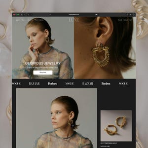 May include: A website interface displaying jewelry products, featuring a gold textured hoop earring with a cage-like design, and a pair of gold hoop earrings with a textured bar detail. The page includes the text LUXE, GLORIOUS JEWELRY, and Shop Now.