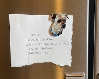 May include: A white piece of paper with a handwritten to-do list on a stainless steel refrigerator. The list includes: Buy pet portrait, Follow @shoptailsbyhails on Instagram, Adopt a pet. A dog magnet is attached to the paper.