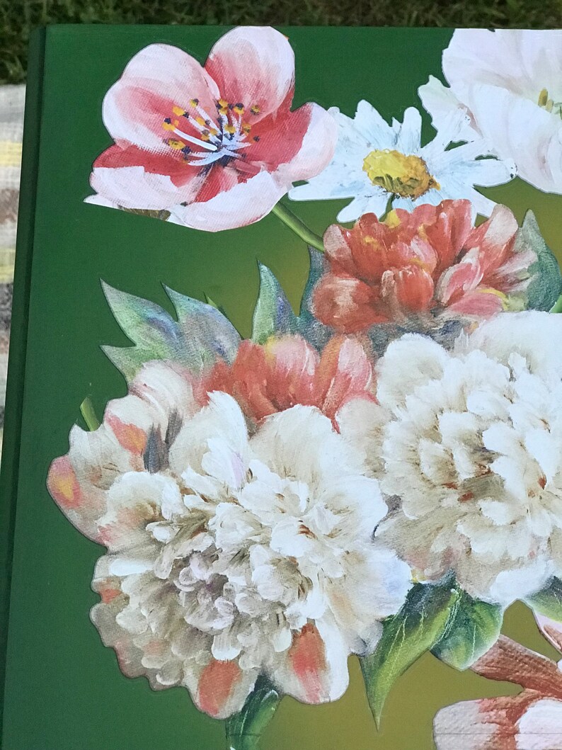Op de afbeelding: Een close-up van een boeket bloemen met witte, roze en rode bloemblaadjes. De bloemen zijn gerangschikt in een vaas op een groene achtergrond.