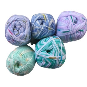 May include: Five balls of yarn in various shades of blue, green, and purple with white and gold accents. The yarn is a variegated pattern.