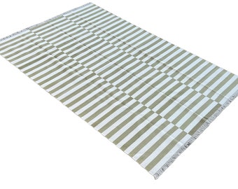 May include: A striped rug with a white and light green color scheme. The rug has a fringe border.