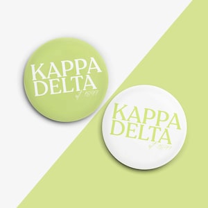 May include: Two round buttons with the text "Kappa Delta est 1897" in white lettering on a green and white background.