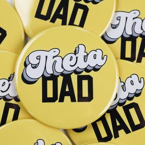 May include: Close-up of several yellow round buttons with the text "Theta Dad" in a retro font. The text is in black and white.