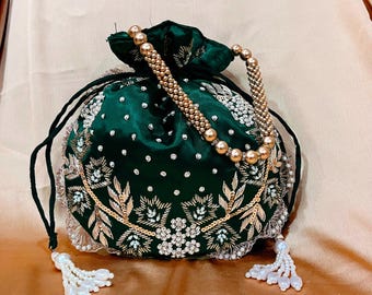 May include: A green satin drawstring bag with gold and white embroidery and pearl accents. The bag has a gold beaded strap and pearl tassels.