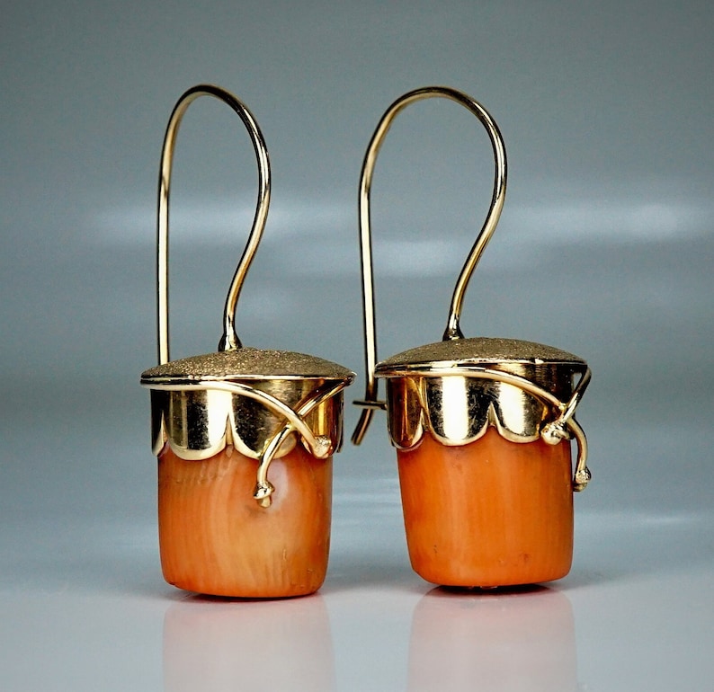 Puede incluir: Un par de pendientes de oro con gotas de coral. Los pendientes tienen un delicado dise&ntilde;o de oro y est&aacute;n acentuados con una parte superior de oro texturizada.