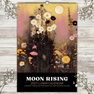 May include: A 2027 wall calendar titled Moon Rising, featuring a vertical illustration of white, yellow, and pink wildflowers against a dark, textured background with a pale moon. The bottom section is a solid black block with white text.