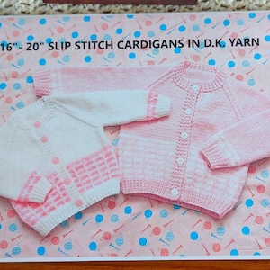 Puede incluir: Dos cárdigans de bebé tejidos en rosa y blanco, exhibidos sobre un fondo estampado. Los cárdigans tienen botones y mangas largas. El texto "16"-20" SLIP STITCH CARDIGANS IN D.K. YARN" está en la parte superior de la imagen.