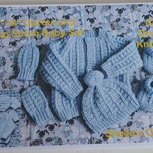 May include: A light blue knitted baby set featuring a cardigan, a hat with a pom-pom, two mittens, and two booties. The text 16-18 Garter and Drop Stitch Baby Set 022 Double Knitting Sheila's Crafty is visible on the image of the set.