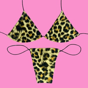 May include: A leopard print bikini set with a triangle top and a thong bottom. The bikini is made of a soft, stretchy fabric and has adjustable straps.