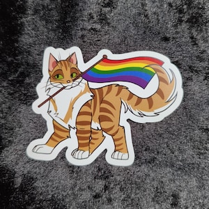 Könnte beinhalten: Ein Aufkleber mit einer Cartoon-Katze mit orange-weißem Fell, die eine Regenbogenfahne hält. Die Katze hat grüne Augen und einen lächelnden Ausdruck. Die Flagge hat die Farben des Regenbogens. Der Aufkleber hat einen weißen Rand.