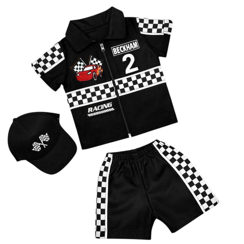 May include: A black short-sleeve collared zip-up shirt with a checkered pattern, a red race car graphic, the text BECKHAM 2 and RACING, matching black shorts with checkered side stripes, and a black baseball cap with a white checkered flag graphic.