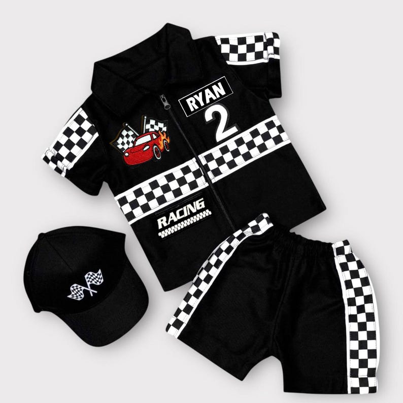 May include: A black short-sleeve collared shirt with a front zipper, featuring a red race car graphic, the name RYAN, the number 2, and the word RACING. It includes black and white checkered patterns, matching black shorts, and a black baseball cap.