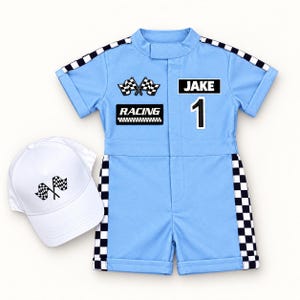 May include: A light blue short-sleeve romper with black and white checkered trim on the sleeves and sides. The chest features patches with crossed checkered flags, the text "RACING", the name "JAKE", and the number "1". A white baseball cap is included.