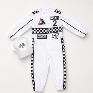 May include: A white long-sleeve racing jumpsuit with black and white checkered trim, featuring the name NOAH, the number 2, the number 55, a red race car graphic, and the word RACING. A matching white baseball cap with two checkered flags.