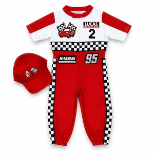 May include: A red and white racing-themed jumpsuit with short sleeves, featuring a checkered pattern, the name LUCAS, the number 2, the number 95, and the word RACING. A matching red baseball cap with two crossed checkered flags is included.