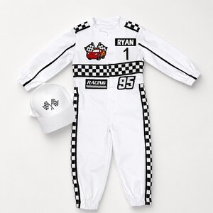 May include: A white long-sleeve racing jumpsuit with black and white checkered trim, featuring a red car graphic, the name RYAN, the number 1, the word RACING, and the number 95. A matching white baseball cap with a checkered flag graphic is included.