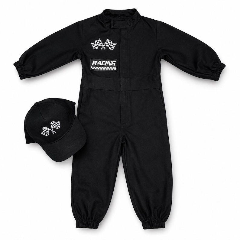 Op de afbeelding: Een zwarte jumpsuit met lange mouwen, elastische boorden en een bijpassende zwarte baseballpet. De jumpsuit is voorzien van een witte afbeelding van twee gekruiste finishvlaggen en een rechthoekige patch met de tekst RACING boven een geblokt patroon.